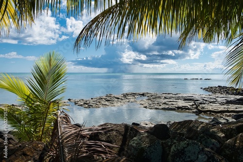 Samoa island beach scene with palm leaves and impressive clouds in the background. Tropical island paradise of samoa. Untouched tropical paradise seascape. Palm trees clouds and ocean landscape. 