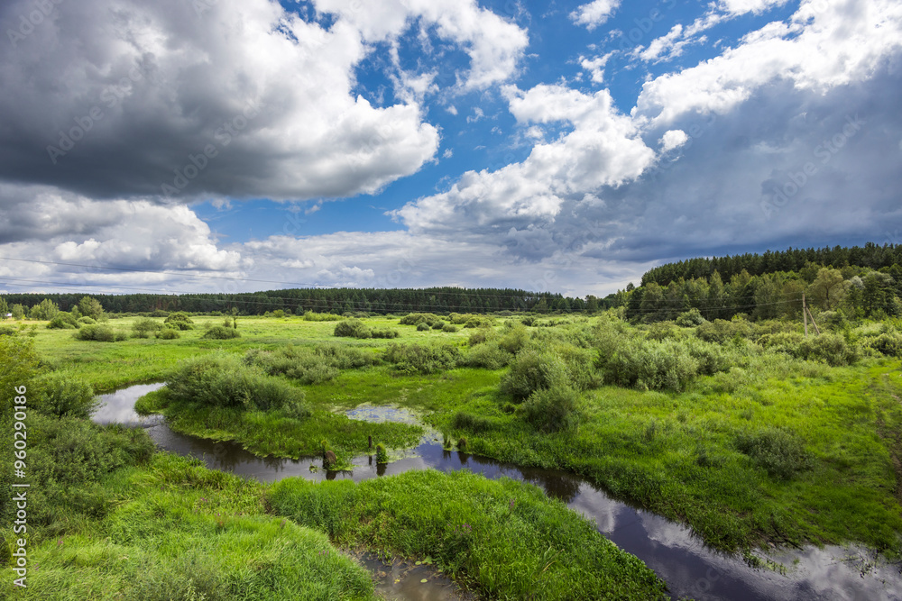 A large, open field with a river running through it A large, open field with a river running through it