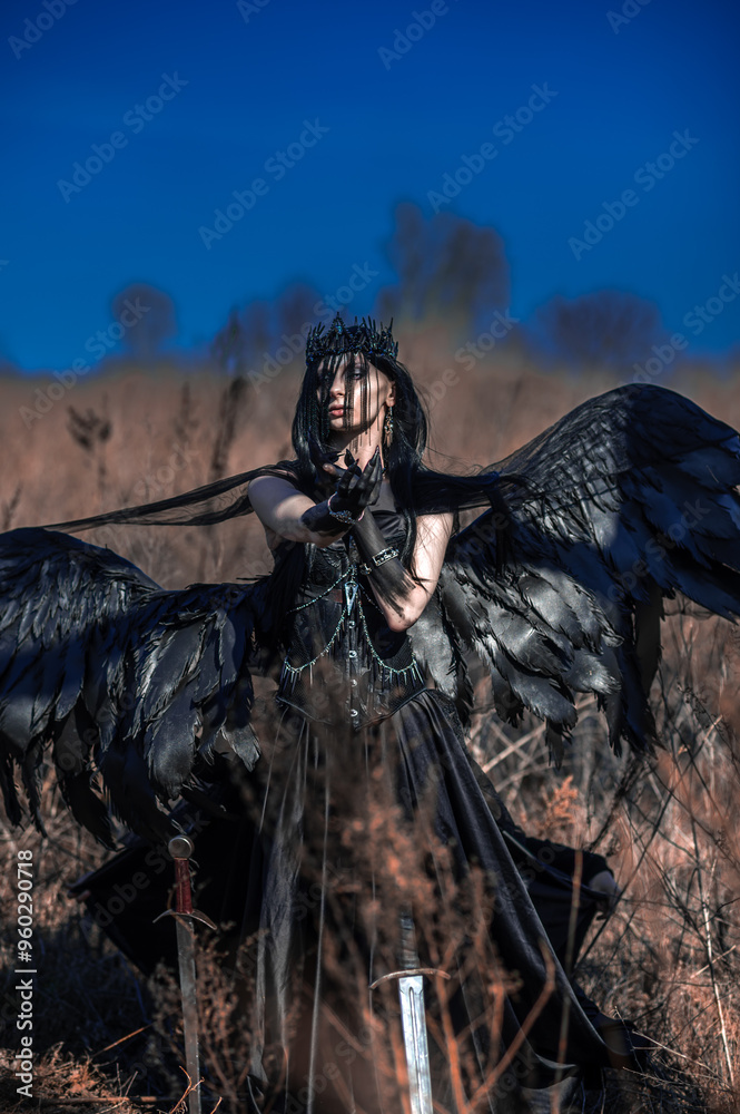 Goddess of death with black wings on a dried field Goddess of death with black wings on a dried field