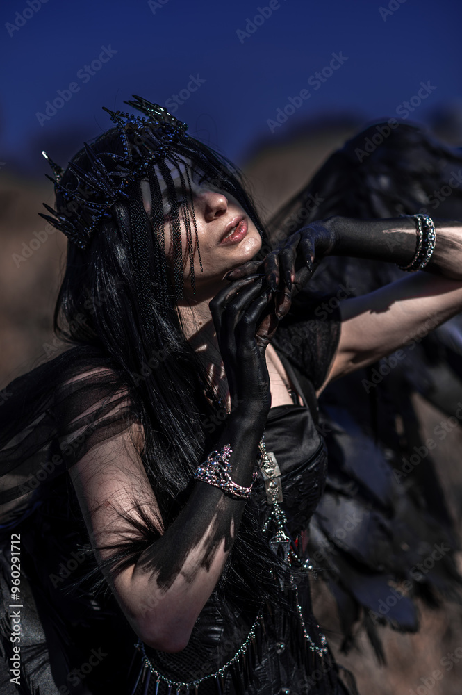 Goddess of death with black wings on a dried field Goddess of death with black wings on a dried field