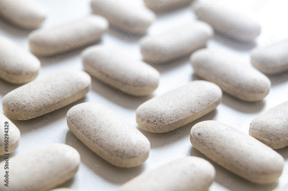 Medical tablets, placed next to each other on a white surface. Therapies, medicines and supplements. Medical tablets, placed next to each other on a white surface. Therapies, medicines and supplements.