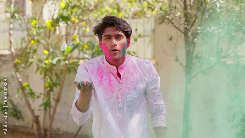 Indian Man Blowing Holi Color at Camera Indian Man Blowing Holi Color at Camera