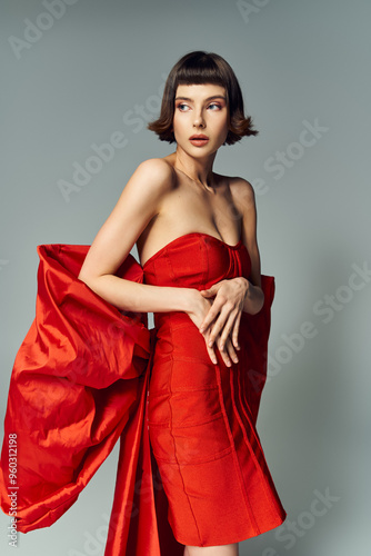 A woman showcases a vibrant red dress, highlighting creativity and elegance.