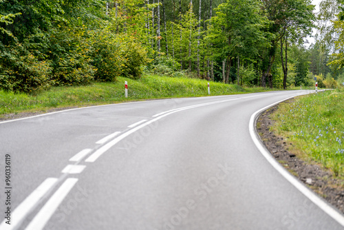 Fototapeta Naklejka Na Ścianę i Meble -  An asphalt road going through a forest in Masuria