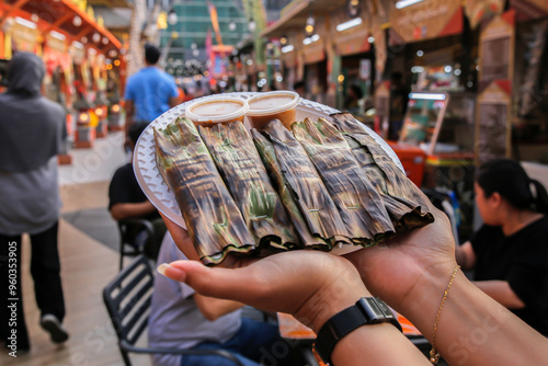  Otak otak ready to be eaten, held in the hand on a plate photo