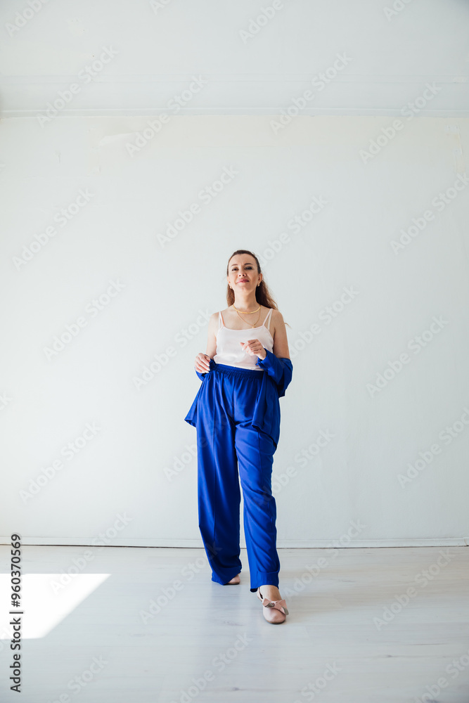 Beautiful woman in blue summer suit in white room Beautiful woman in blue summer suit in white room