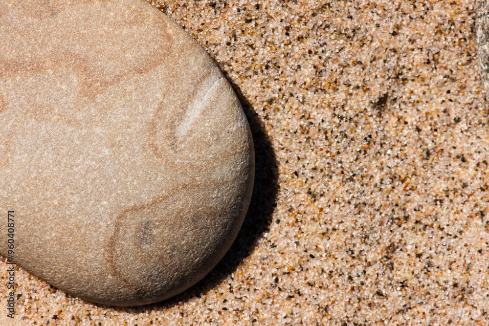 Lone stone casts its shadows over the beach sand grains at Kohler-Andrae State Park, Sheboygan, Wisconsin in late winter Lone stone casts its shadows over the beach sand grains at Kohler-Andrae State Park, Sheboygan, Wisconsin in late winter