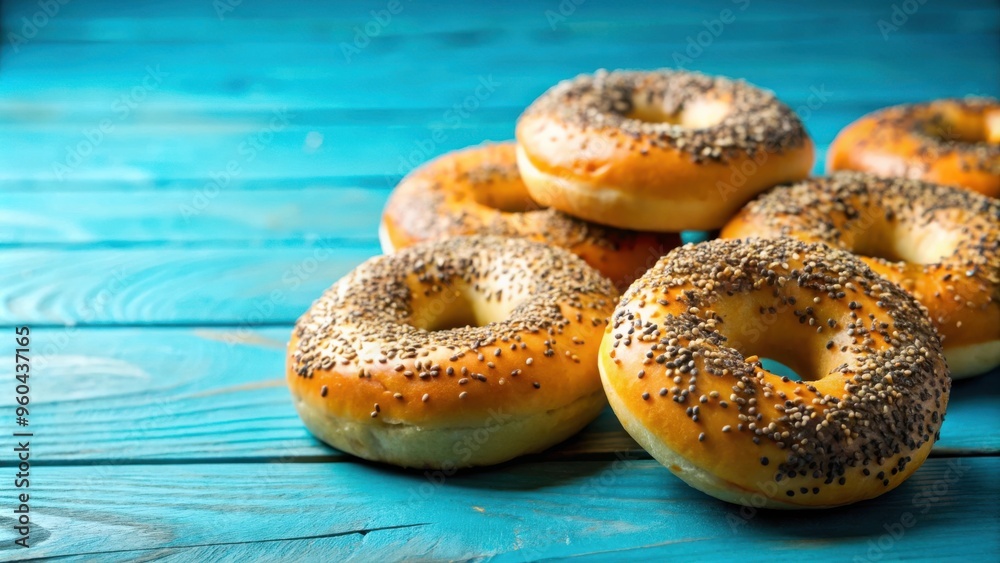 Freshly baked bagels with sesame and poppy seeds on a blue background Freshly baked bagels with sesame and poppy seeds on a blue background