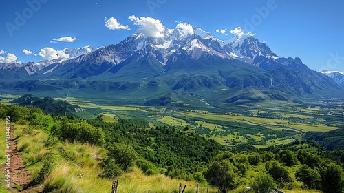 Majestic snow-capped mountain range surrounded by lush greenery. Nature and serenity concept