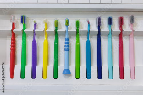 There are many different colored toothbrushes in a row at the exhibition.