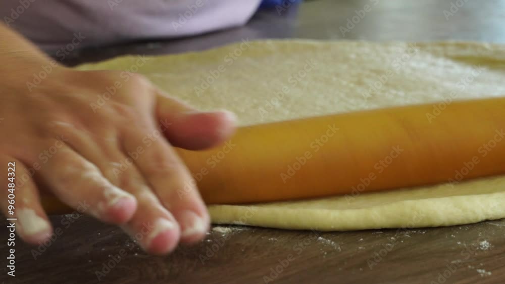 Woman is rolling the dough Woman is rolling the dough