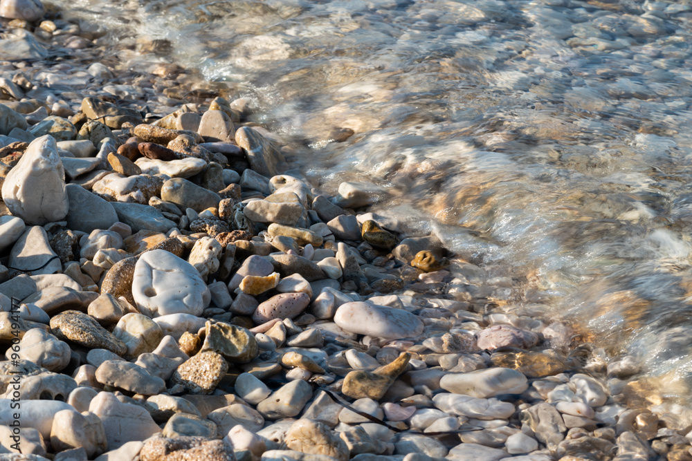 Sea water covers beach stones, bubbles in water Sea water covers beach stones, bubbles in water