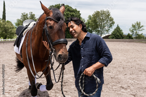A groom caring for a brown horse at an equestrian center