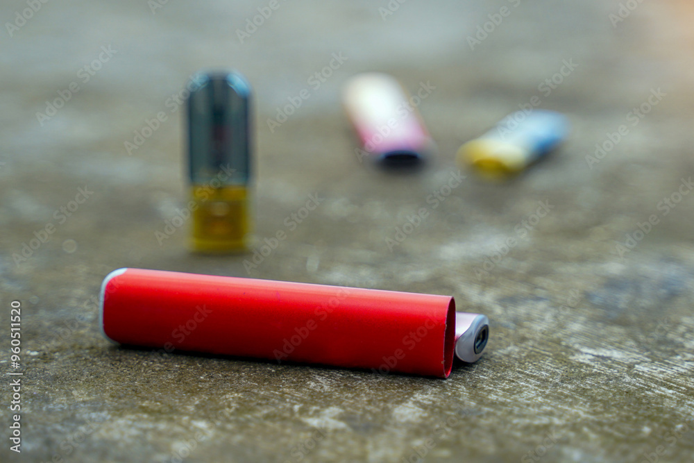 Many brands of e-cigarettes on the cement floor, concepts of types of cigarettes, harms and dangers, addictive substances. Many brands of e-cigarettes on the cement floor, concepts of types of cigarettes, harms and dangers, addictive substances.