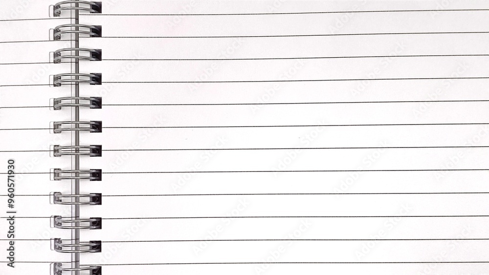 Top view of a spiral notebook, highlighting its carefully coiled metal binding that securely holds the pages together. Top view of a spiral notebook, highlighting its carefully coiled metal binding that securely holds the pages together.