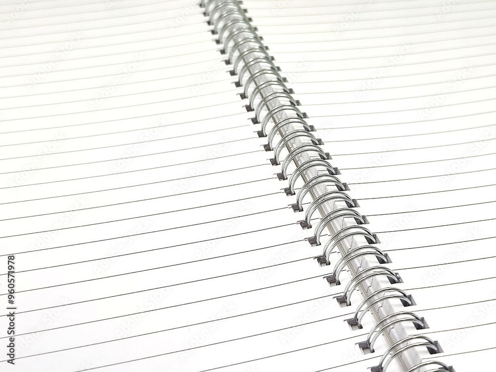 Top view of a spiral notebook, highlighting its carefully coiled metal binding that securely holds the pages together. Top view of a spiral notebook, highlighting its carefully coiled metal binding that securely holds the pages together.