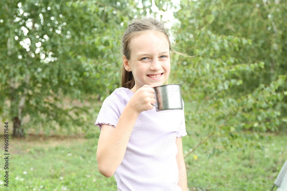 Cute girl with metal mug outdoors. Camping season Cute girl with metal mug outdoors. Camping season