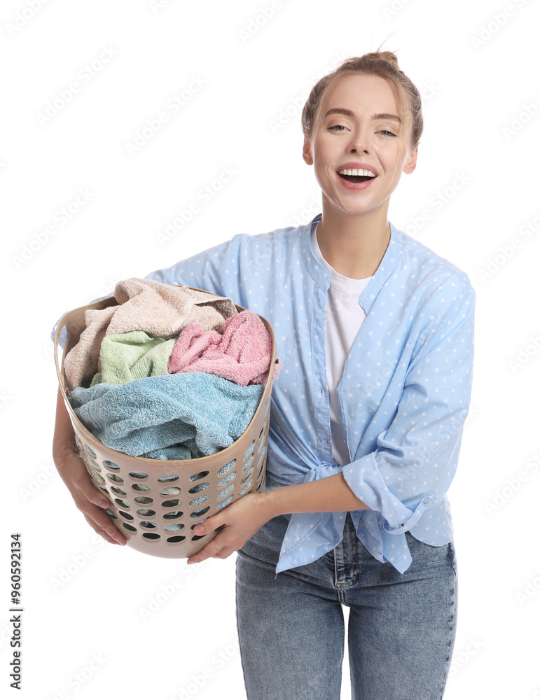 Happy young housewife with basket full of laundry on white background