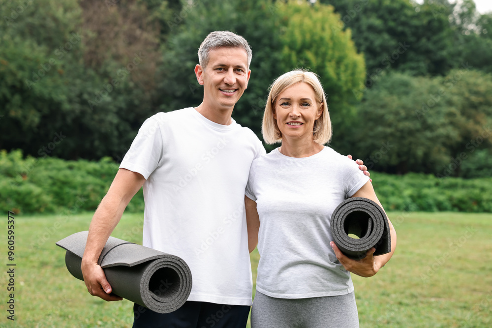 Happy couple with yoga mats in park Happy couple with yoga mats in park