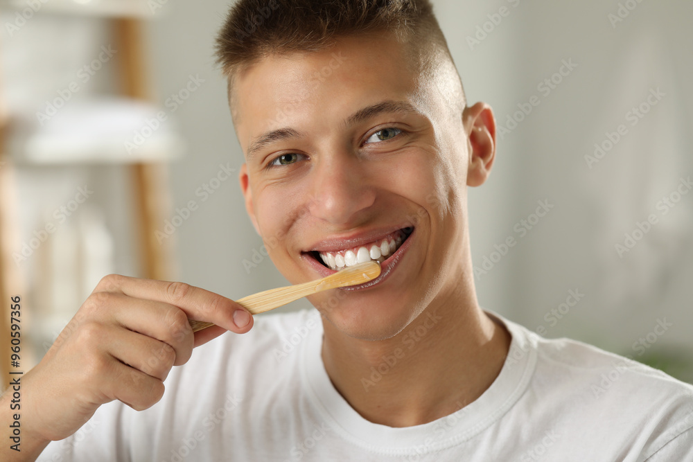 Young man brushing his teeth in bathroom Young man brushing his teeth in bathroom