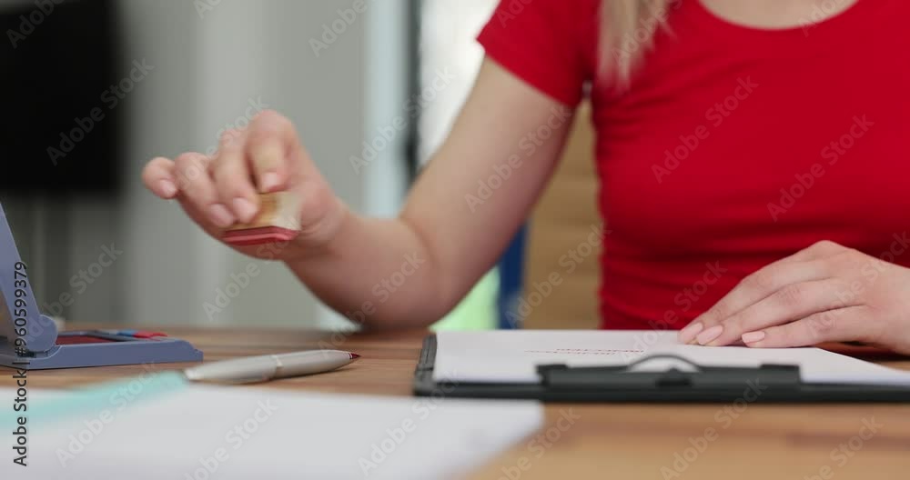 Female hand puts stamp on papers signing agreement in company office. Woman prepares documentation to start cooperation with new supplier