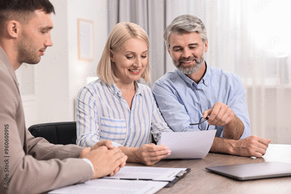 Pension plan. Couple consulting with insurance agent at table indoors Pension plan. Couple consulting with insurance agent at table indoors