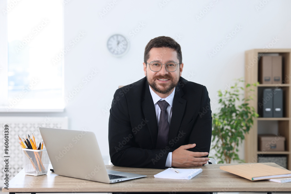Portrait of smiling businessman at table in office Portrait of smiling businessman at table in office