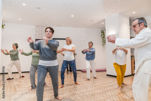 Canvas Print A group of people are practicing Tai Chi in a room