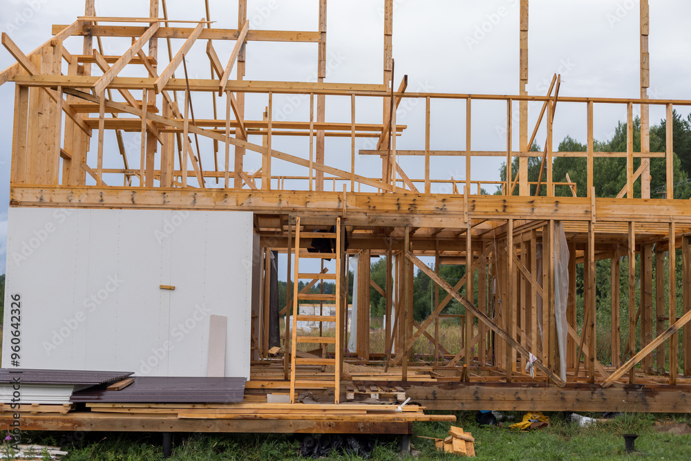 Construction of a house outside the city. The frame of the house on stilts. The concept of life in the village. There are fields and woods around. Construction of a house outside the city. The frame of the house on stilts. The concept of life in the village. There are fields and woods around.