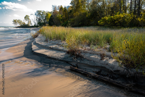 Lake Michigan waves during earlier stomrs work to erode the beach sand at Harrington Beach State Park, Belgium, Wisconsin in early October, while the dune grass works to stabilize the banks.