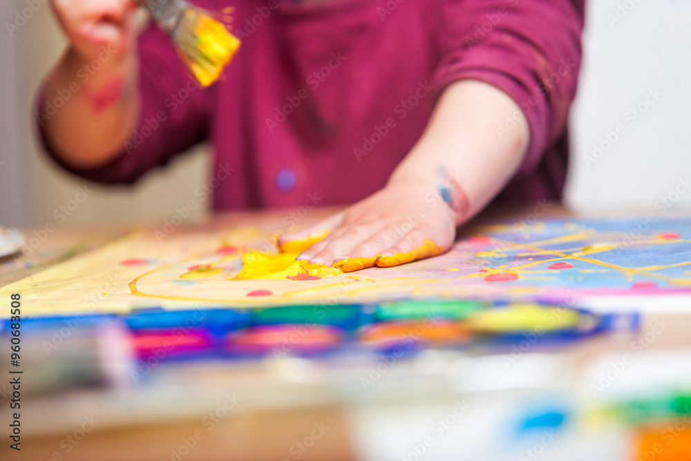 Close-up of a child's hands painting a piece of paper with a brush and his hands. Close-up of a child's hands painting a piece of paper with a brush and his hands.