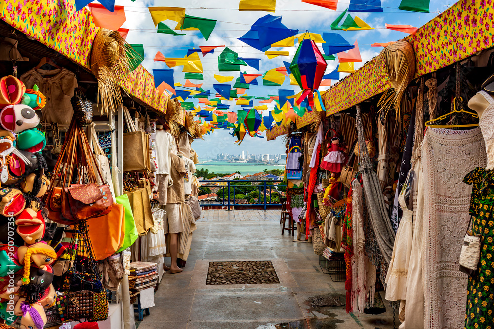 Obraz premium Brazilian street with shops for tourists in Olinda with a view of the city of Recife in the background