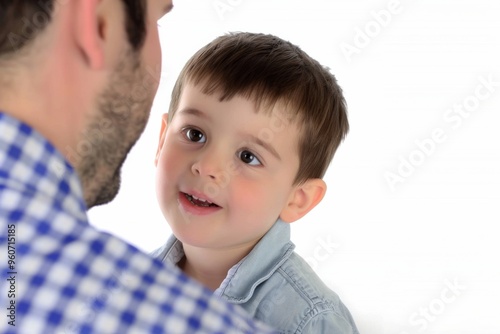 A touching moment between a little boy and his father captured against a bright white background during a joyful family day