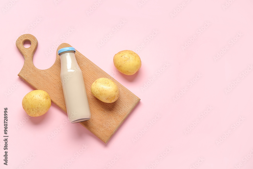 Bottle of tasty potato milk on pink background Bottle of tasty potato milk on pink background