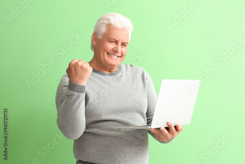 Happy senior man using lapt...