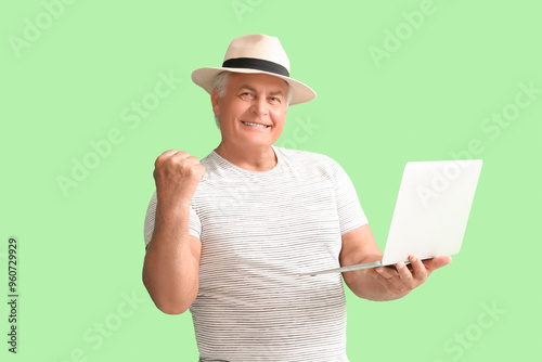 Happy senior man with lapto...