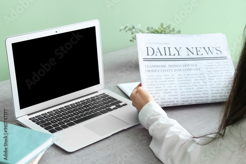 Young woman reading newspap...