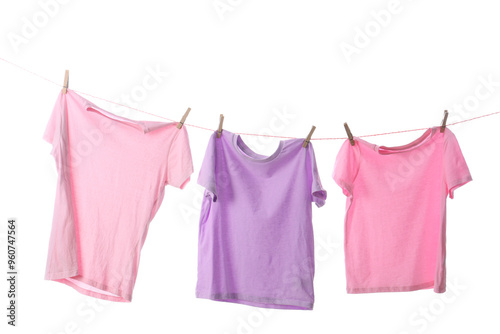 Stylish t-shirts hanging on rope against white background