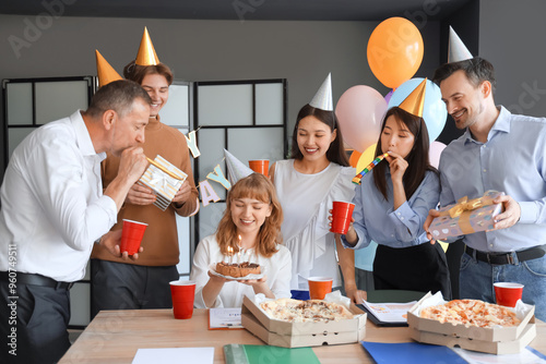 Photography Young businesswoman with cake and her colleagues at birthday party in office