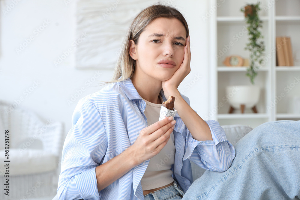 Young woman with sweet candy suffering from tooth ache at home Young woman with sweet candy suffering from tooth ache at home