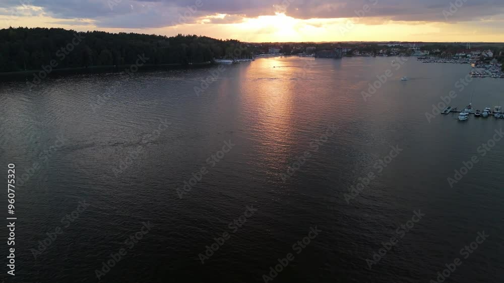 4K panoramic aerial view to Mikolajki townscape during sunset - capital of Masurian region. Mikolajskie lake sunset