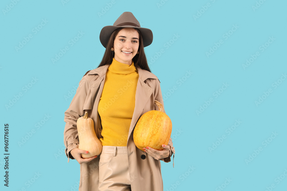 Beautiful young happy woman with pumpkins on blue background Beautiful young happy woman with pumpkins on blue background
