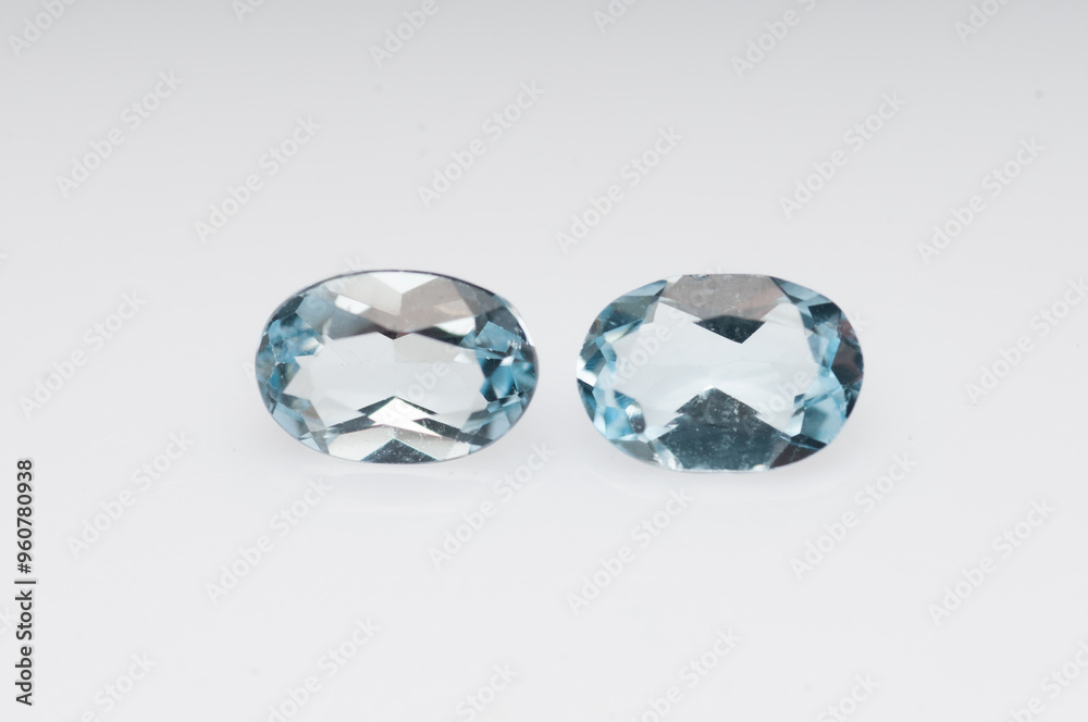 Elegant Display of Two Sparkling Blue Aquamarine Gems on White Background Elegant Display of Two Sparkling Blue Aquamarine Gems on White Background