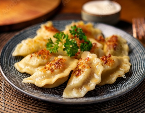 Close-up of a plate of traditional Polish pierogi filled with cheese and potatoes photo