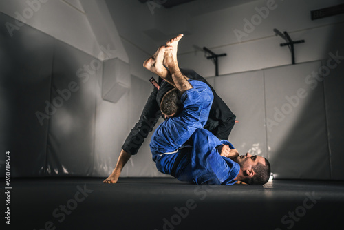 BJJ Brazilian Jiu jitsu Athlete fighters training sparing technique at the academy fight in gi kimono photo