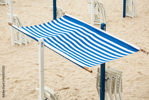 Verano en la playa con los toldos y sombrillas en la arena 