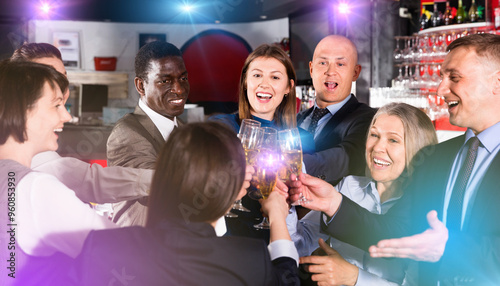 International group of glad cheerful positive businesspeople toasting with champagne, having fun at office party in nightclub