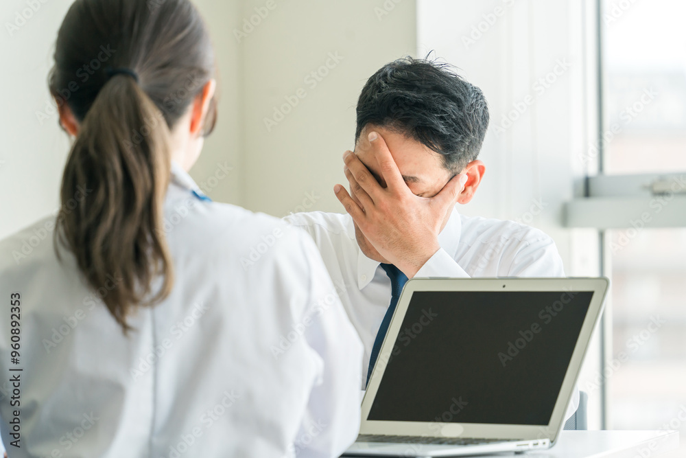 Obraz premium 病気の病名告知をされてショックを受ける男性と医者 