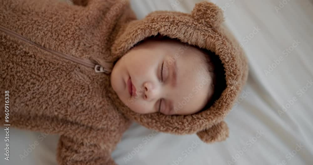 Comfort, development and growth with baby sleeping on bed of home in onesie for rest from above. Cute, dreaming and relax with face of infant child asleep in bedroom of apartment for peace or quiet Comfort, development and growth with baby sleeping on bed of home in onesie for rest from above. Cute, dreaming and relax with face of infant child asleep in bedroom of apartment for peace or quiet