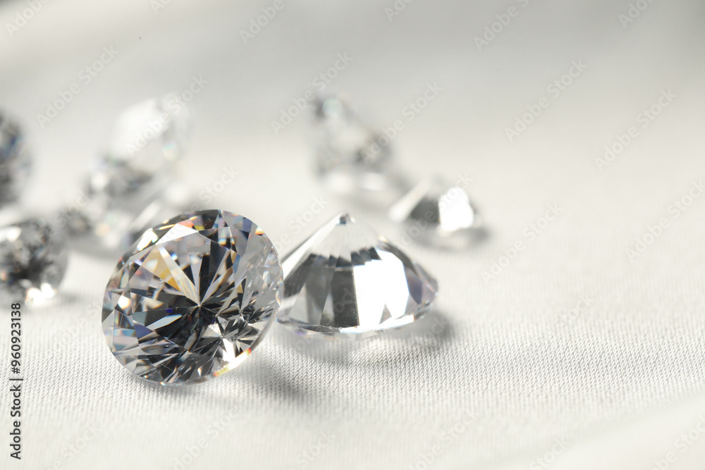 Many beautiful shiny diamonds on white fabric, closeup. Space for text Many beautiful shiny diamonds on white fabric, closeup. Space for text